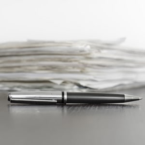 Contracts on a table with a pen., Arrangement Contracts Can Be Similar to a Restraining Order