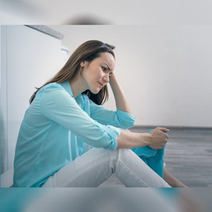 Upset woman sitting on the floor of a house