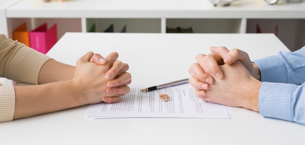 Wedding rings on a contract indicating divorce settlement