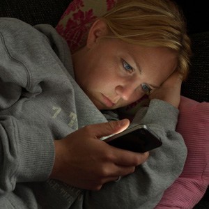 Blonde lady reading texts late at night