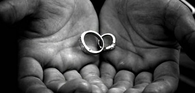 Hands holding wedding rings. Many are rushing to get divorced before the new year to save money.