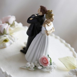 Divorcing couple wedding cake topper indicating reasons to divorce.