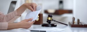 Woman taking money out of an envelope with a gavel on her desk indicating alimony