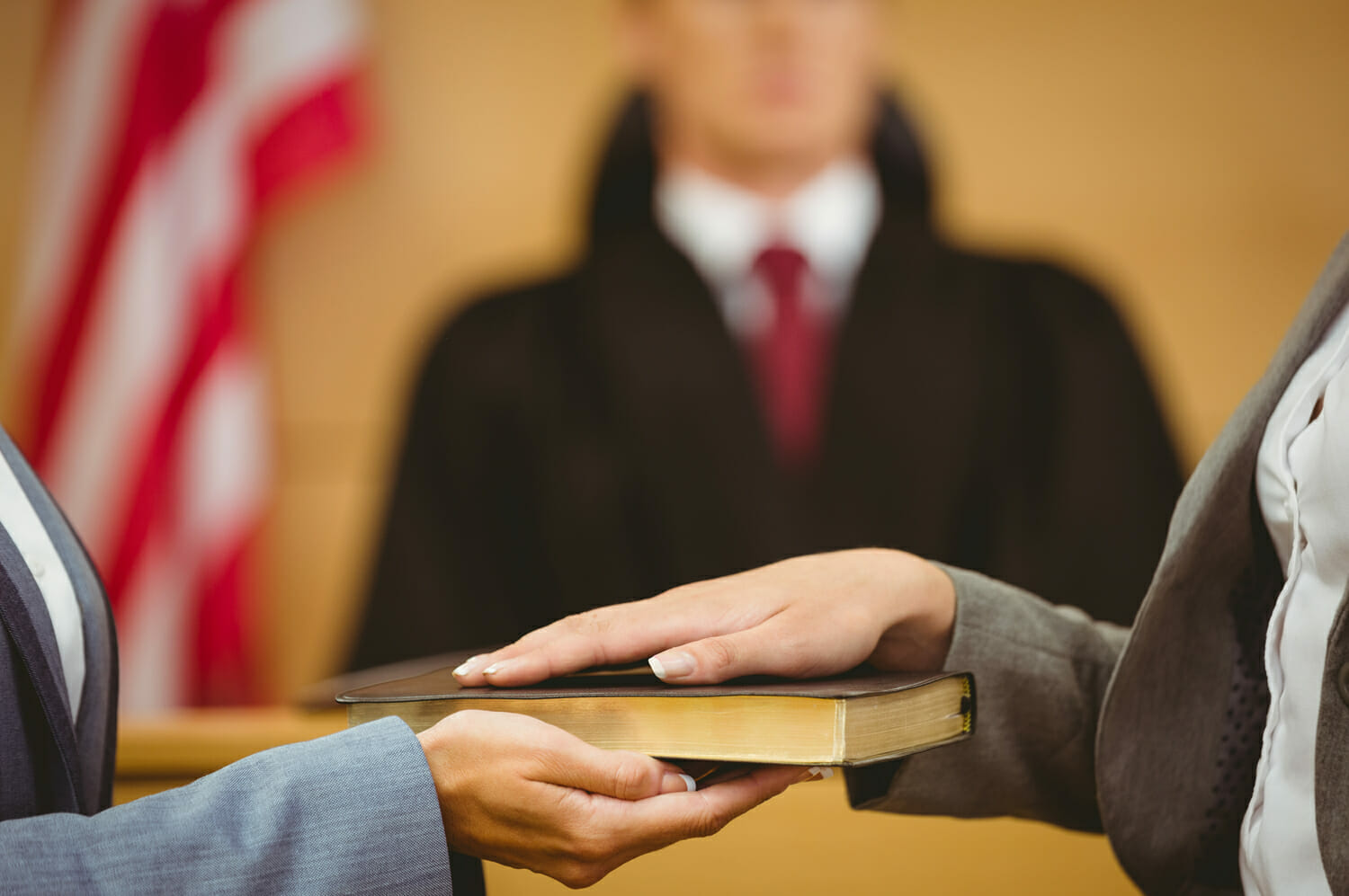 A person swearing in before a judge in court