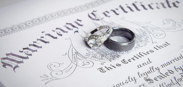Marriage certificate with wedding rings on it