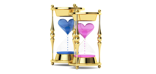 Pink and blue golden hourglasses against a white background