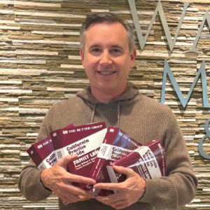 Top Family Law Attorney Christopher C. Melcher Standing with several copies of Rutter Guide Books