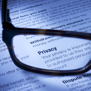 A Document with the word privacy on it magnified by the glasses on top of the paper indicating privacy and prenups