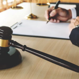 A judge writing on his desk next to a gavel